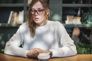 A close up picture showing a women sitting on a table