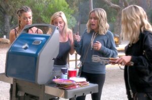 Picture of four women standing and having sandwiches