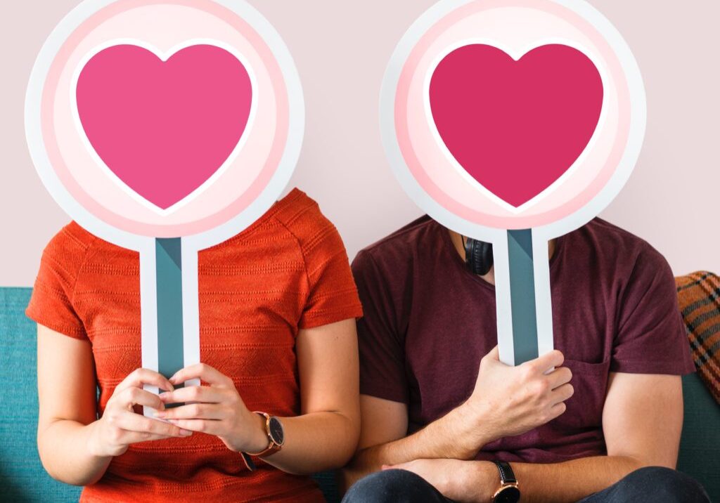A picture of man and women holding puck card of heart shape