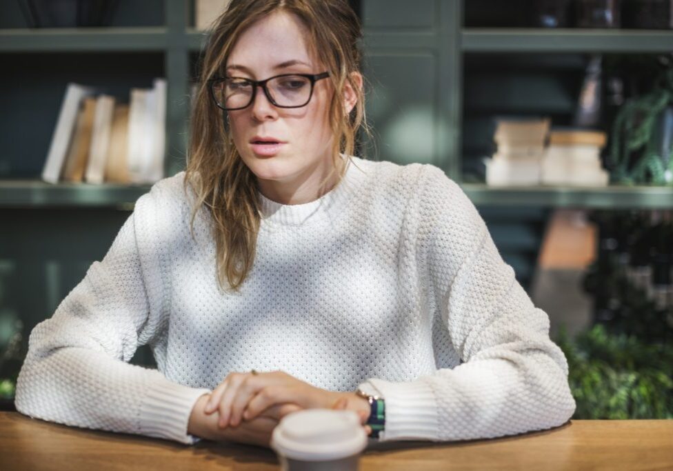 A close up picture showing a women sitting on a table